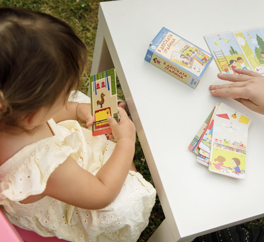 Детенце играе с картите В детската градина
